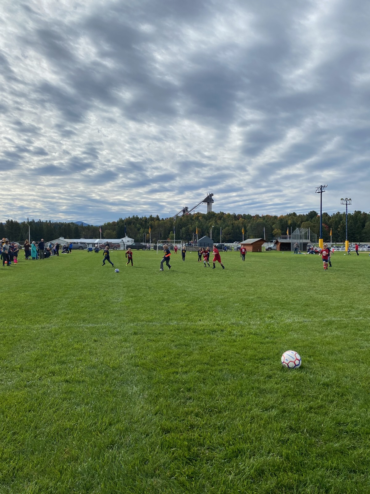 Children playing soccer with the Olympic ski jumps in the background
