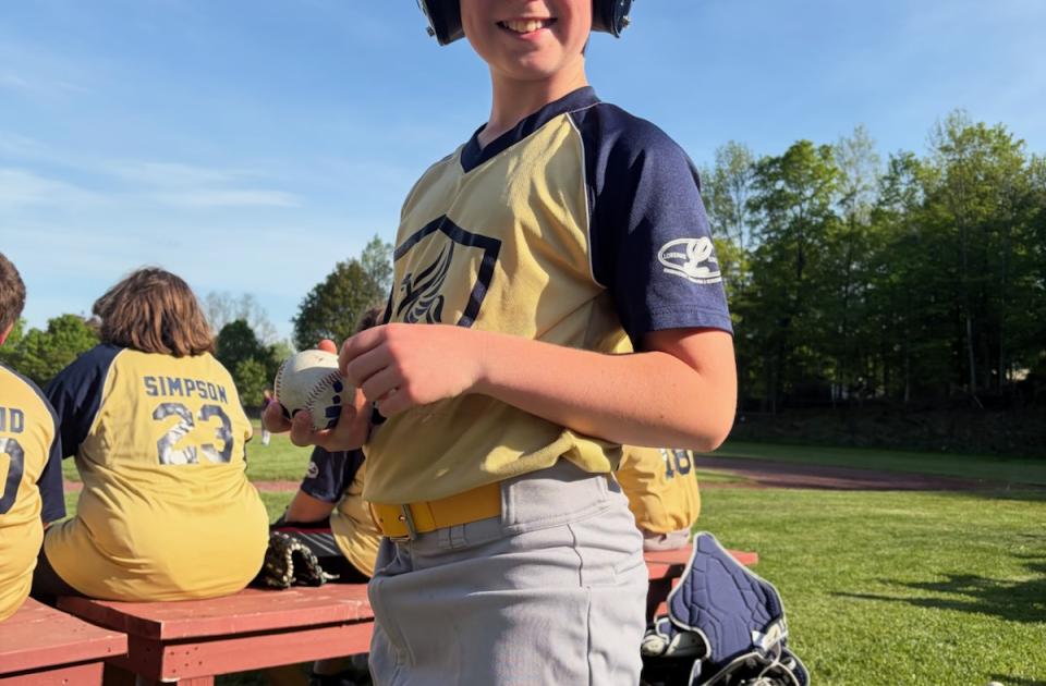 Boy smiling getting ready to play baseball